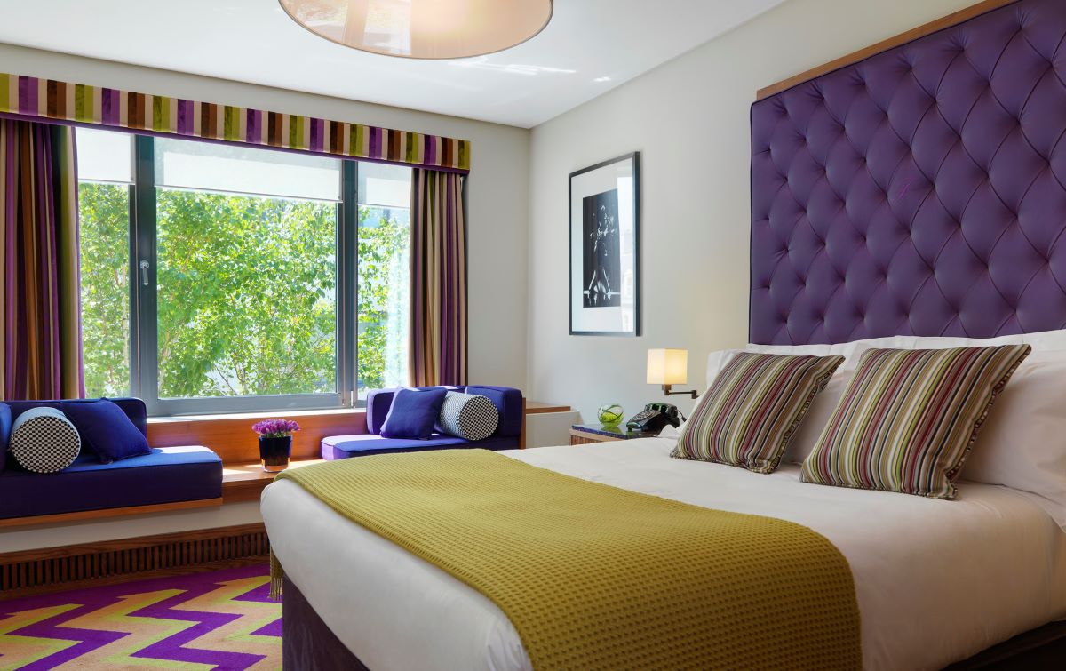 A king room with a king bed and a window and some seating at the Fitzwilliam Hotel in Dublin.